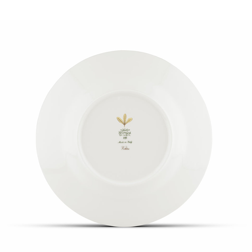 White ceramic plate with a gold emblem on a white background