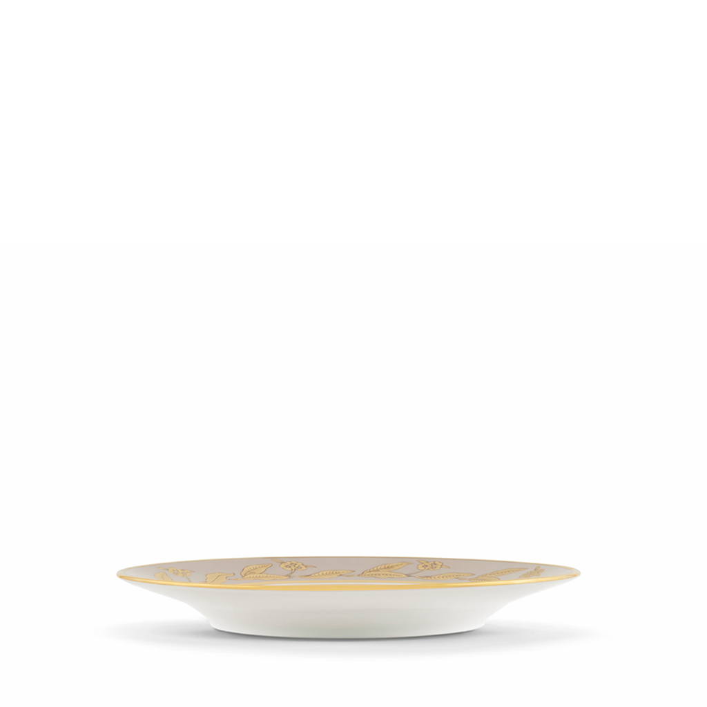White plate with gold rim and decorative elements on a white background
