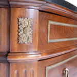Close-up of a wooden panel with decorative carvings and gold accents.