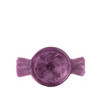 A single purple wax melt or solid candle shaped like a wrapped candy, shown from a top-down view on a solid white background.