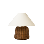 Table lamp with wicker base and white shade on a white background