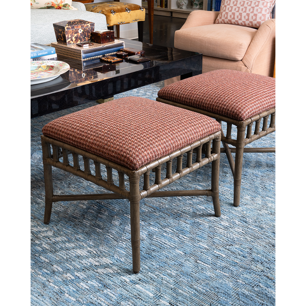 two ottomans in a living room with a blue rug