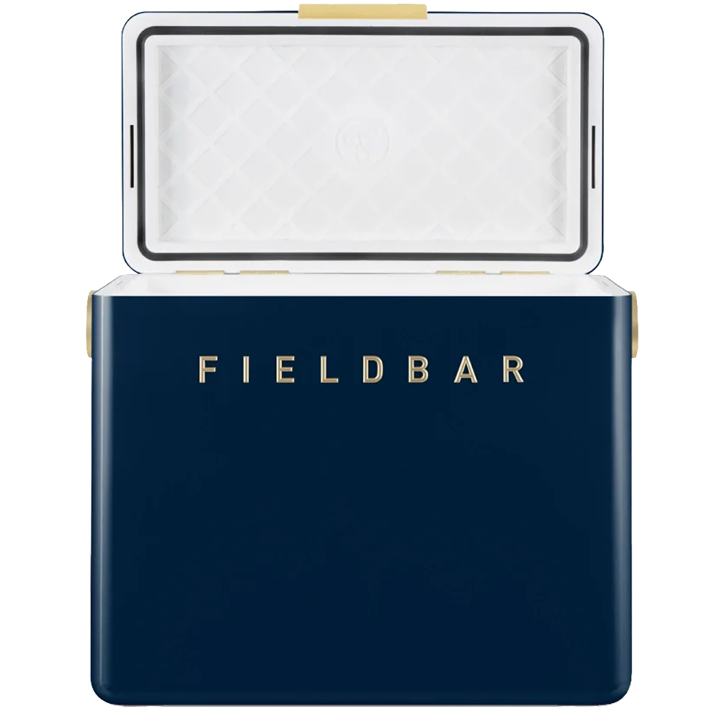 The navy blue FIELDBAR cooler is shown with its lid open, revealing a white insulated interior with a quilted pattern and a black sealing gasket around the edge. Gold lettering on the front and gold hardware accents complement the cooler's clean, premium design against a white background.