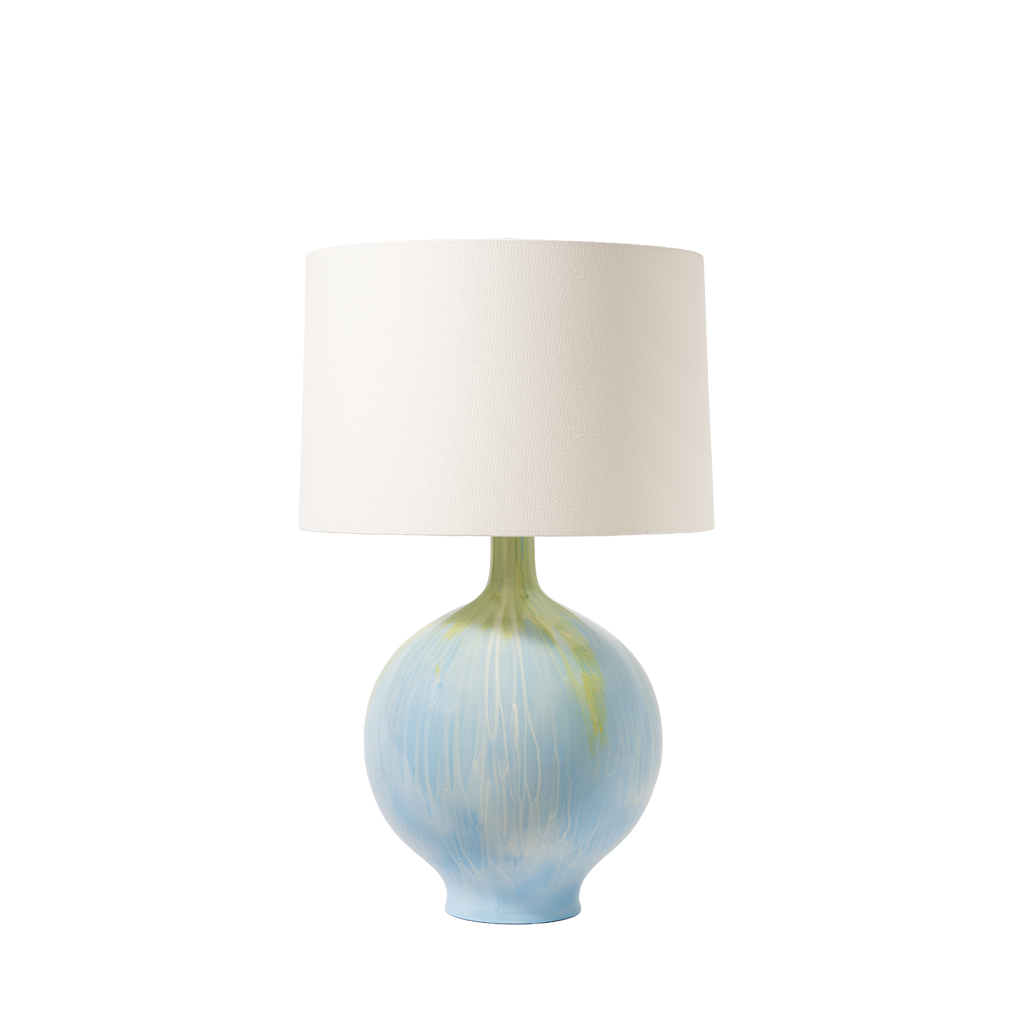 Table lamp with a white shade and blue and green base on a white background