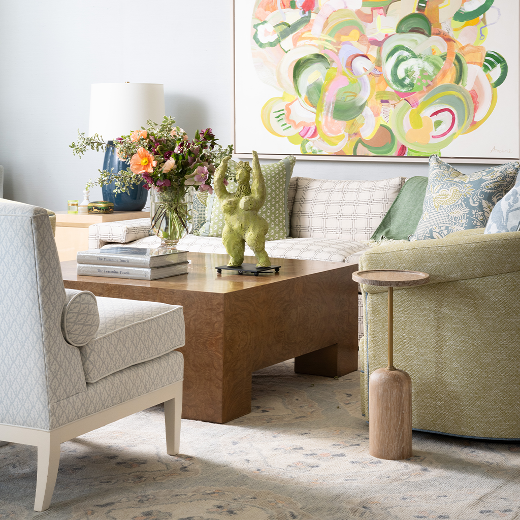 Modern living room with a sofa, armchair, coffee table, and decorative elements.