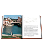 Open book showing a scenic view of a town with a canal and people walking.