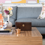 Wooden box on a wooden coffee table with decorative items in a living room setting.