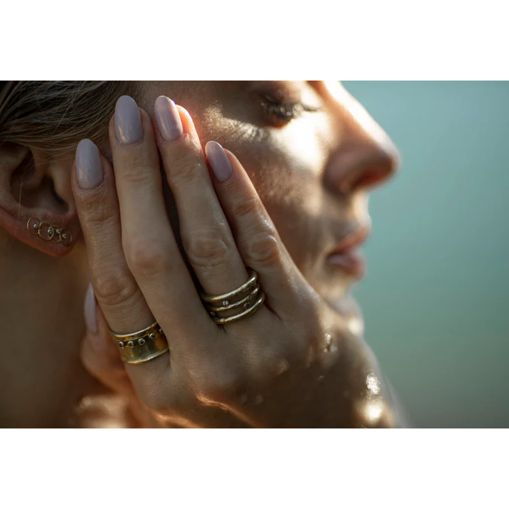 Close-up of a woman's hand with gold rings and a blurred background