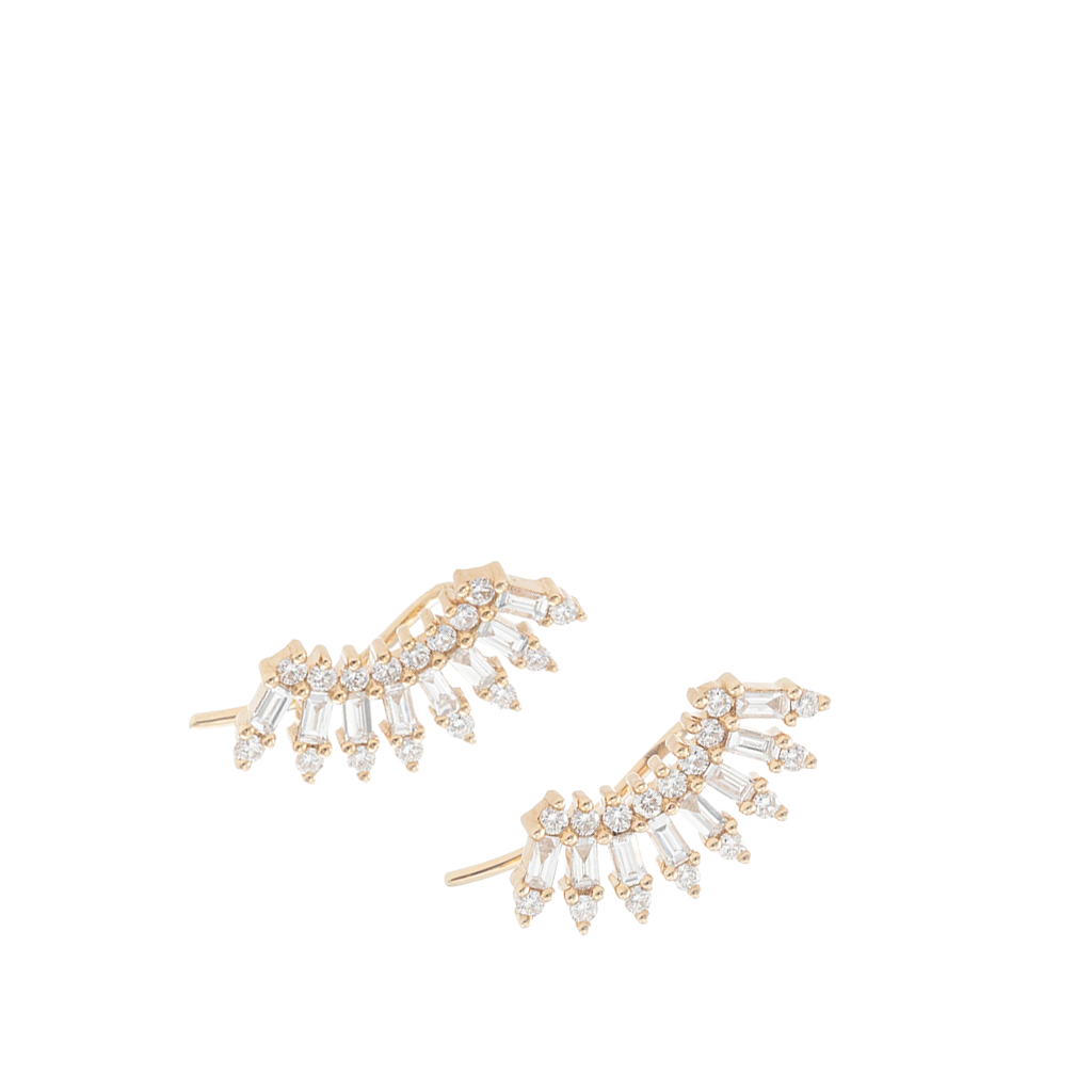 A pair of gold crescent-shaped stud earrings adorned with baguette-cut clear crystals, set against a plain white background.