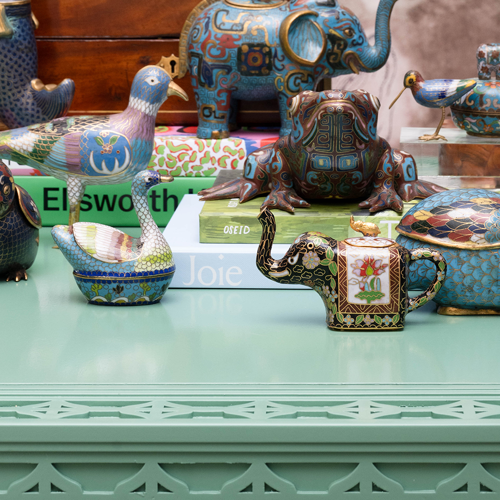 Miniature Cloisonne Elephant Teapot next to other trinkets