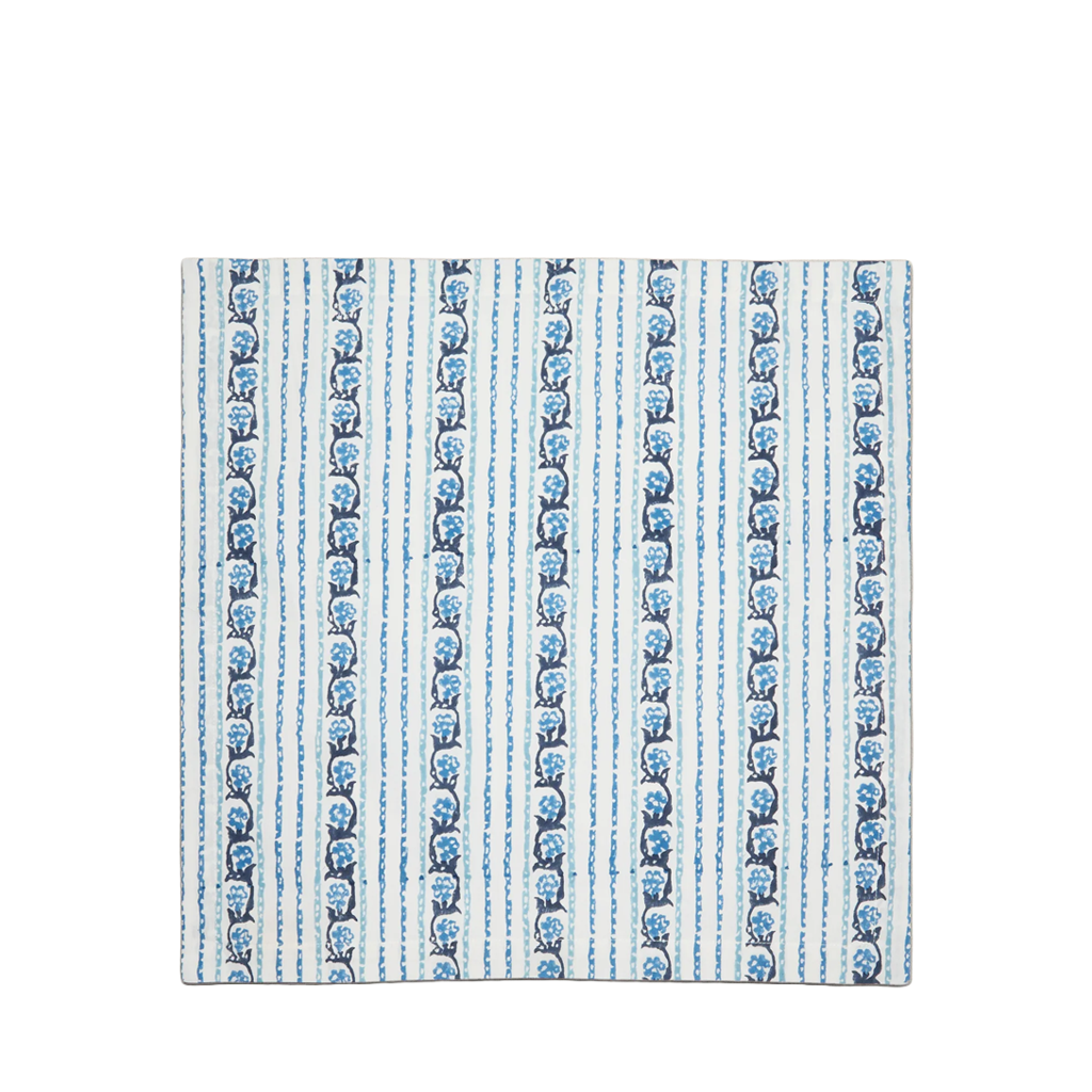 A square fabric napkin featuring a vertical striped pattern with blue motifs on a white background.