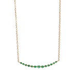 Gold necklace with green gemstones on a white background
