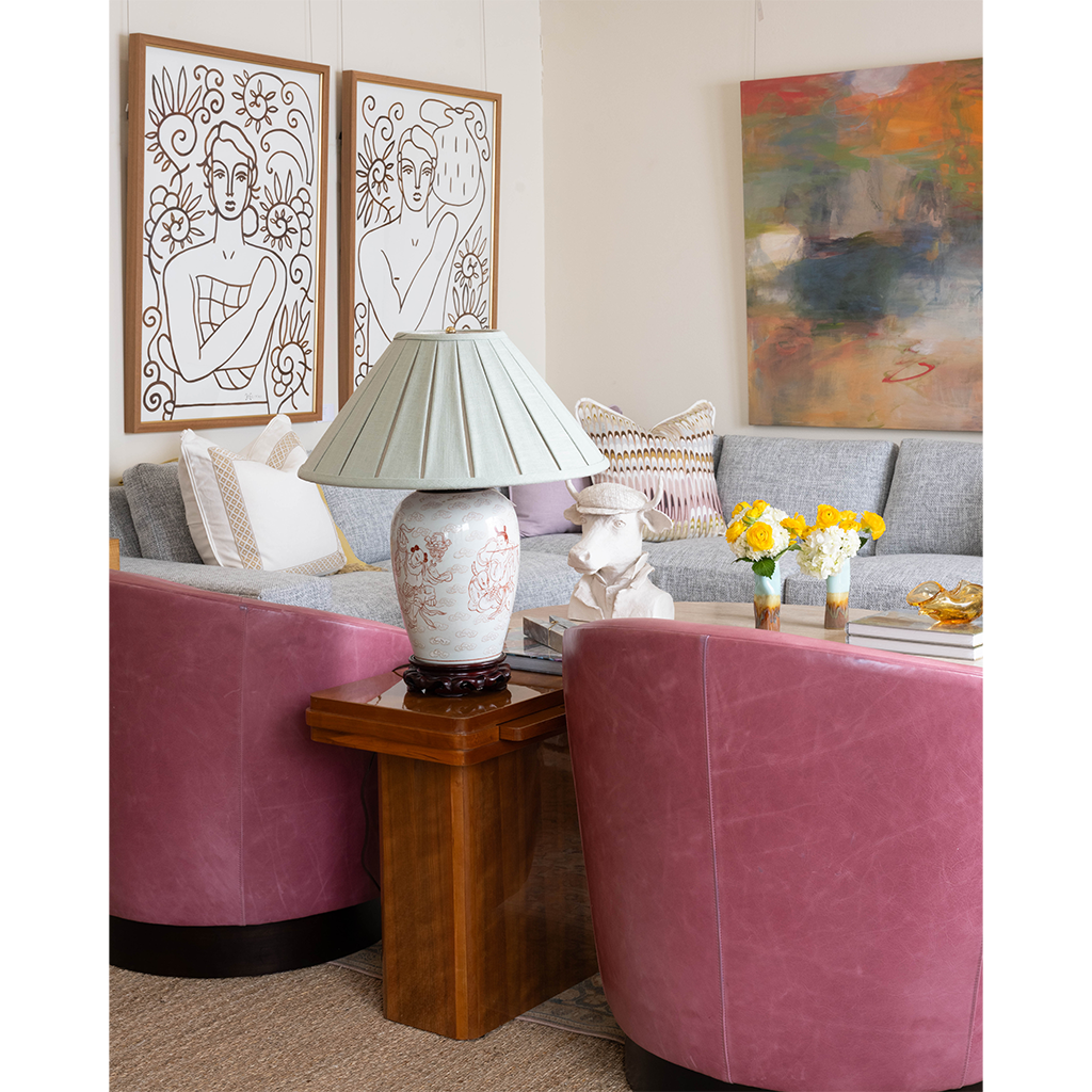 pink chairs with brown side table with lamp on top