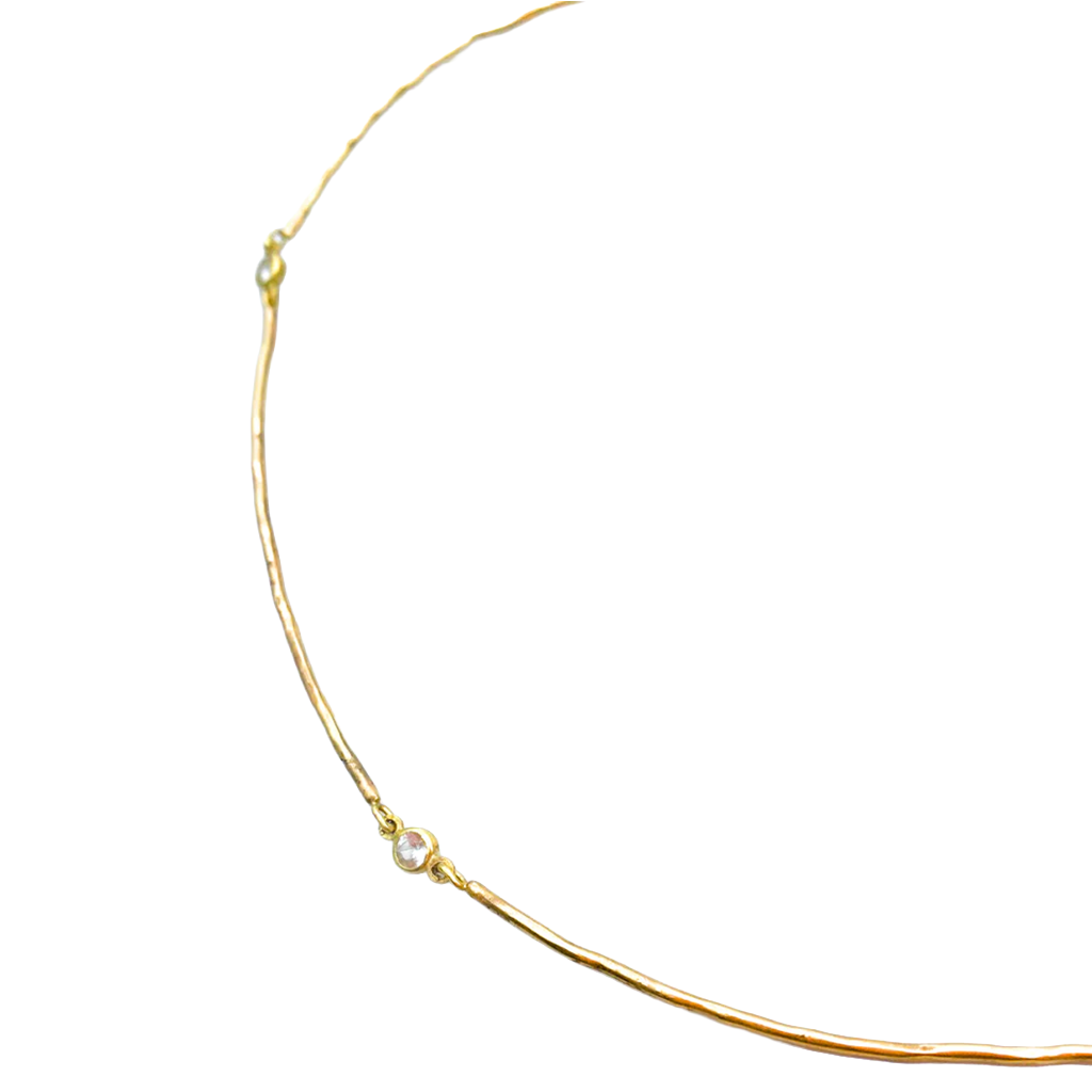 Gold necklace with a small diamond pendant on a white background