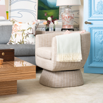 Modern living room with a beige armchair, wooden coffee table, and decorative elements.