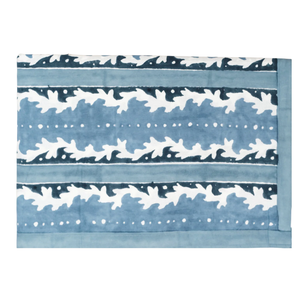 A rectangular textile featuring a blue and white ikat pattern with horizontal bands of abstract motifs and dotted lines.