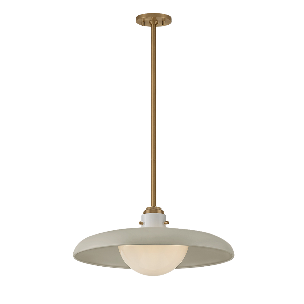 A modern pendant light fixture with a brushed brass suspension rod and canopy, featuring a wide, shallow drum shade in a warm off-white color with a frosted glass globe bulb inside, shown against a plain white background.