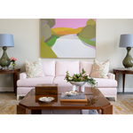 Living room with a pink sofa, coffee table, and decorative elements.