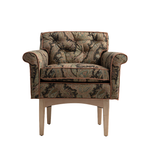 A classic tufted armchair with rolled arms, upholstered in a detailed paisley patterned fabric with a warm brown border, supported by light-colored wooden legs, shown against a plain white background.