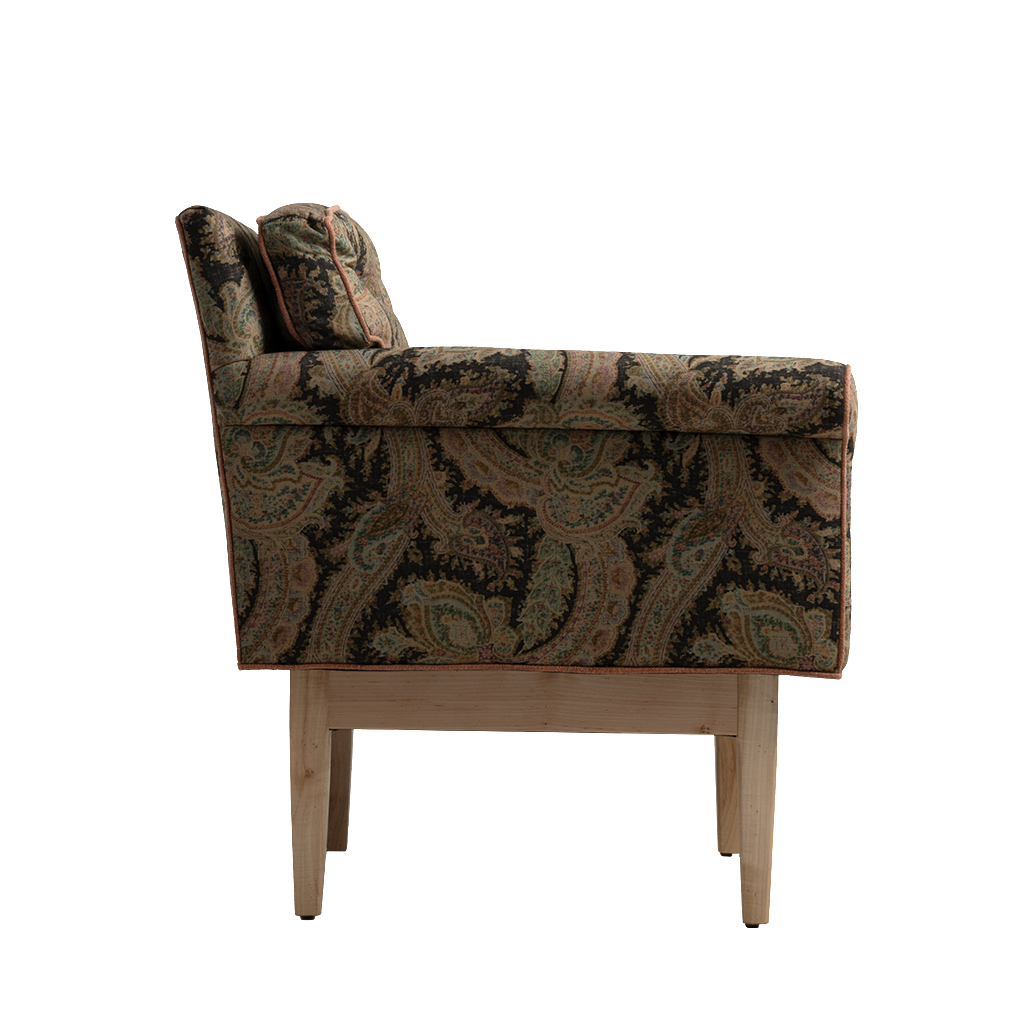 A single upholstered armchair shown from the side against a plain white background. The chair has a dark paisley patterned fabric in black, brown, and muted green tones, with light natural wood legs.