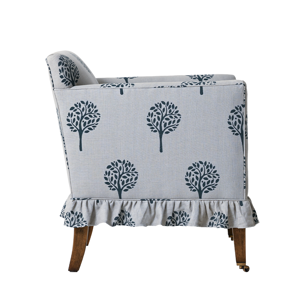 Chair with a gray slipcover featuring blue tree patterns on a white background