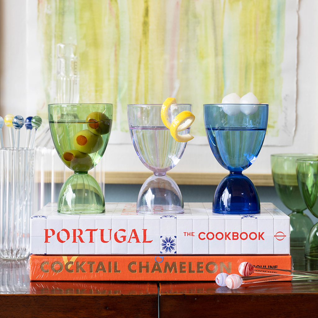 Martini glasses lined up on top of a coffee table book