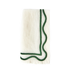 A folded white linen napkin with dark green geometric embroidery on the edges.
