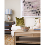 Living room with a white sofa, decorative pillow, and coffee table with a bowl.