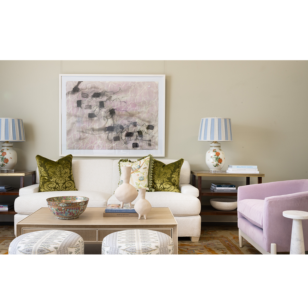 Living room with a white sofa, green cushions, and a painting on the wall.