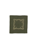 An olive green square fabric napkin with a beige embroidered leafy wreath border on a plain white background.