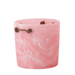 pink resin ice bucket with leather handles on a white background
