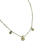 Gold necklace with small circular diamond pendants on a white background