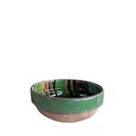 A small handmade ceramic bowl with a glossy green glazed rim and a matte terracotta clay base, shown against a plain white background.