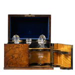 A luxury wooden wine and water storage box with an open lid, featuring a dark blue velvet interior, a burl wood-grain front, brass hinges, and glass decanters and wine glasses displayed inside.