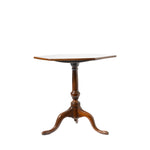 A small hexagon wooden pedestal table with a light-colored top and three curved legs, shown against a plain white background.