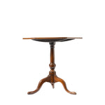 A vintage wooden pedestal table with a hexagon top, turned central column, and three curved legs, shown against a plain white background.