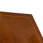 Close-up of a polished brown wooden surface with a thin gold-toned inlay line forming a corner on a white background.