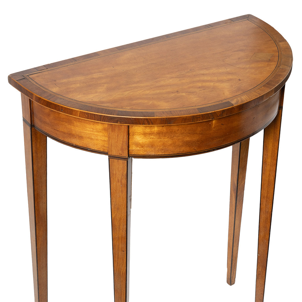 A vintage-style wooden console table with a semi-circular half-moon top, featuring a warm medium-brown wood finish and four slender legs, shown against a plain white background.