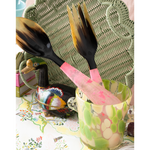 Decorative salad servers with a colorful ice bucket on a patterned surface