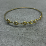 Gold bracelet with small diamonds on a gray surface