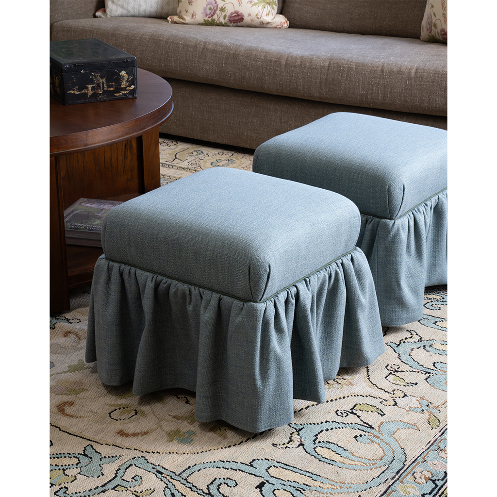 A pair of blue ottomans on a patterned rug