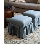A pair of blue ottomans on a patterned rug