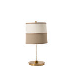 Table lamp with beige shade and brass base on a white background