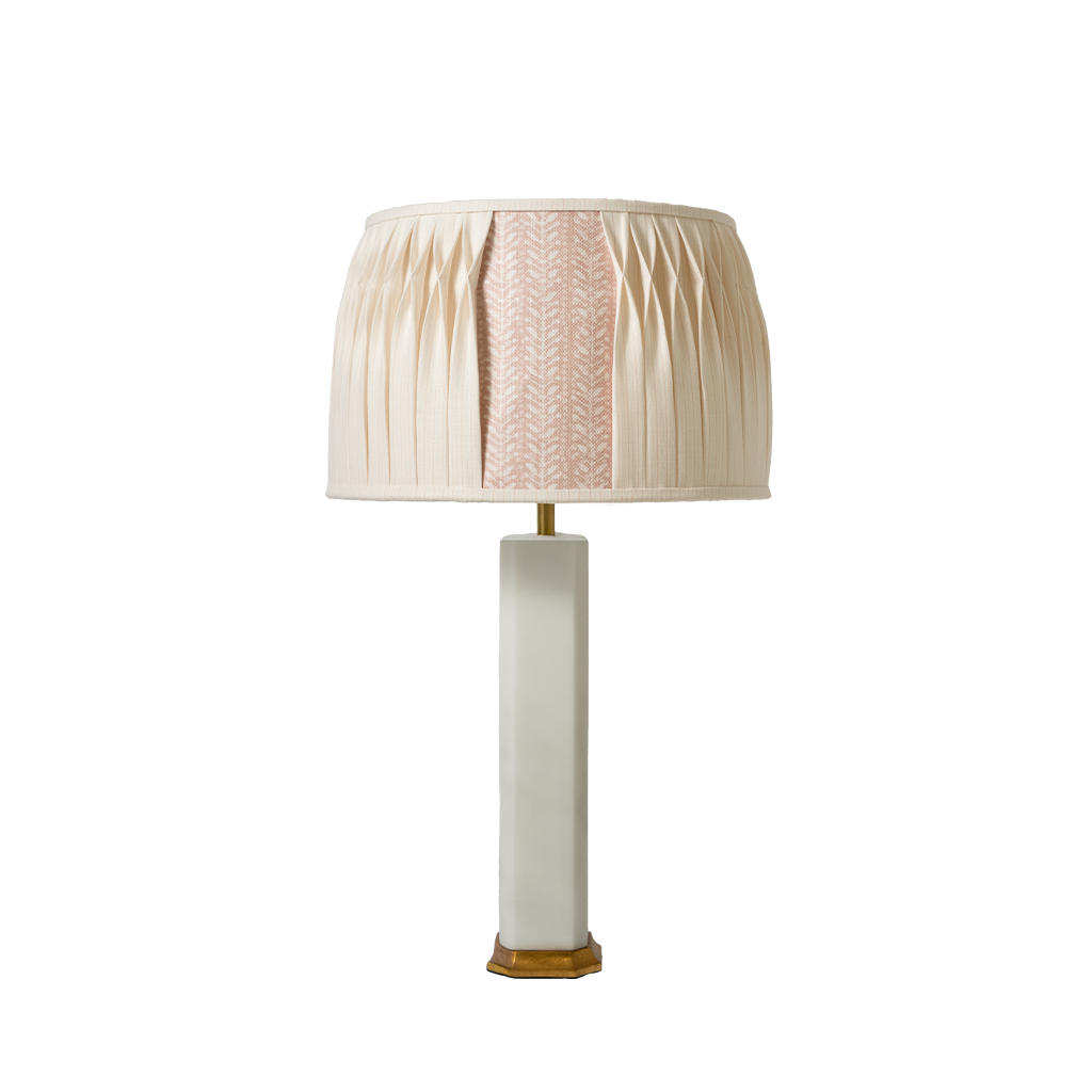 Table lamp with a pleated beige shade on a white background