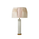 Table lamp with a pleated beige shade on a white background