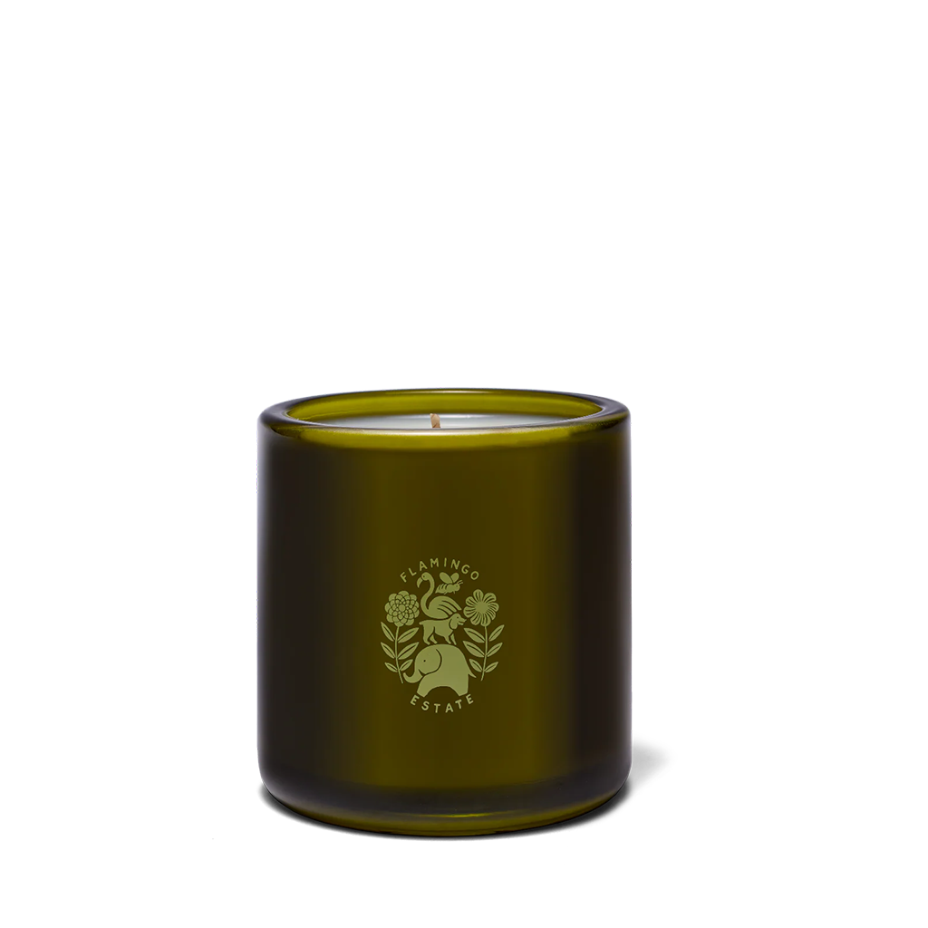 An olive green glass jar candle with a matching green printed logo of a rabbit and flowers on the front, set against a plain white background.
