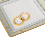 Gold hoop earrings on a decorative glass surface