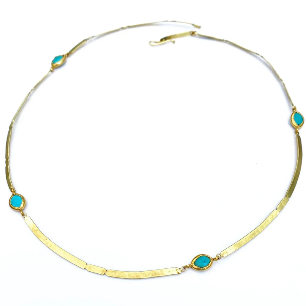 Gold necklace with turquoise stones on a white background
