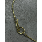 Close up of Gold necklace with decorative elements on a gray surface