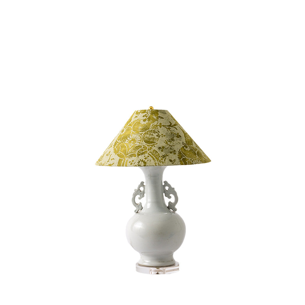 A table lamp with a glossy white ceramic vase-shaped base featuring decorative side handles, topped with a conical fabric shade in olive green and cream floral pattern.